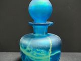 a blue glass bottle with a blue swirl on it