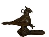 an image of a bird figurine sitting on top of a piece of wood