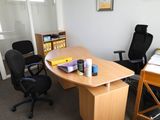 a desk with a chair and a book shelf in the corner