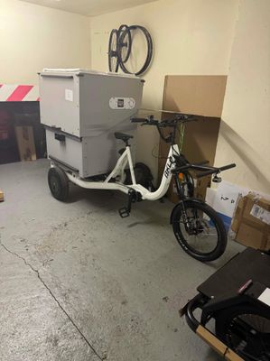 un vélo auquel est attelée une remorque, dans un garage