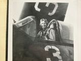 black and white photograph of a man sitting in the cockpit of a plane