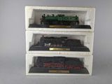 three toy trains sitting on display on a shelf