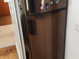 un réfrigérateur marron orné d'aimants, dans une cuisine