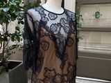black lace top on a mannequin stand in front of a potted plant