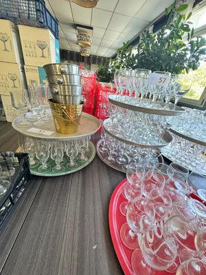 de nombreux verres posés sur une table où se trouvent également des assiettes et des tasses