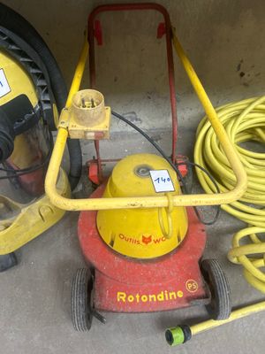 une machine rouge et jaune et un tuyau jaune posé par terre