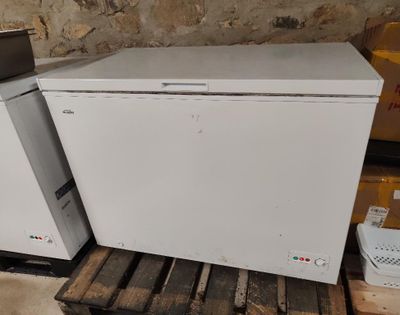 deux réfrigérateurs blancs posés sur une palette dans une pièce
