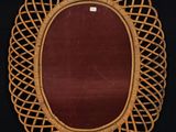 an oval wicker picture frame with a red velvet lining