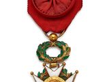 Gros plan sur une médaille sur fond blanc, accompagnée d'un ruban rouge