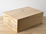une caisse en bois sur laquelle est collée une étiquette, posée sur un plancher en bois