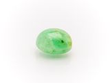 a close up of a green jade stone on a white surface