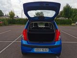 a blue car with its trunk open in a parking lot
