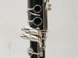 a close up of a clarinet with a black body and silver keys