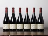 six bouteilles de vin alignées sur une table en bois