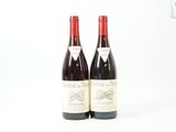 deux bouteilles de vin rouge posées l'une à côté de l'autre sur une surface blanche