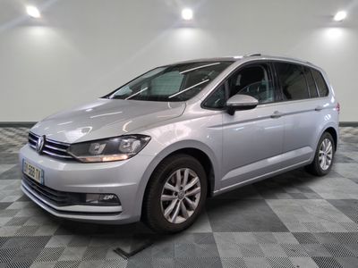 a silver volkswagen touran is parked in a room with a checkered floor