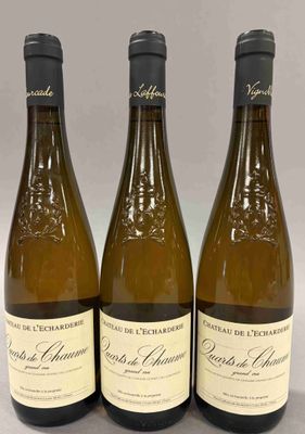 trois bouteilles de vin posées sur une table l'une à côté de l'autre