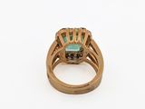 a close up of a gold ring with a green stone in the center