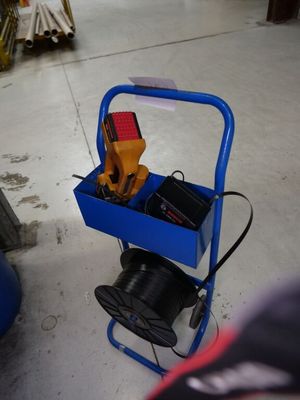 un chariot bleu posé par terre, contenant des outils