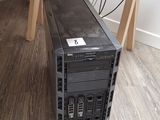 un petit ordinateur noir posé sur un bureau en bois dans une pièce
