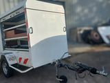 une petite remorque blanche à laquelle est attaché un vélo