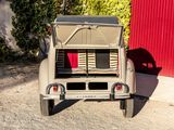 an old car parked in front of a red building