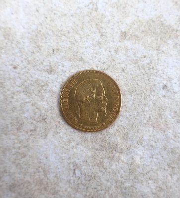 a close up of a gold coin on a white surface