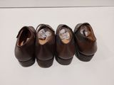three pairs of brown shoes are lined up on a white surface