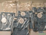cinq paires de jeans sont emballées dans des sacs en plastique sur une table