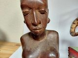 a statue of a woman with a book on a table