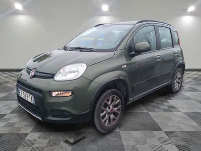 La petite voiture verte est garée sur un sol en carrelage à damier.
