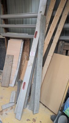 plusieurs pièces de bois sont empilées dans un entrepôt