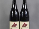 deux bouteilles de vin posées sur une table l'une à côté de l'autre