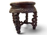 a small wooden stool with carvings on the top of it