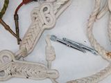 a white rope with a knot on it next to scissors and a pair of scissors
