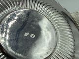 a silver plate with a silver lid on a table