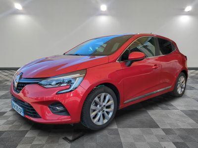 une voiture rouge garée dans un garage au sol en damier