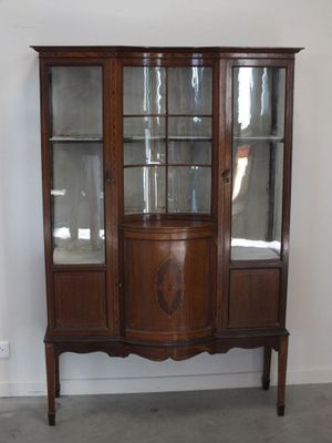 un vaisselier en bois avec des portes en verre dans une pièce