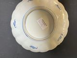 blue and white porcelain bowl on black table with label on it