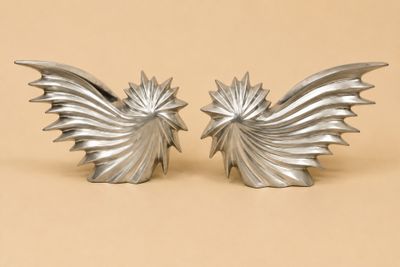 une paire d'ailes d'ange en métal argenté sur fond beige