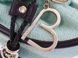a purse with a keychain and a bag charm on it