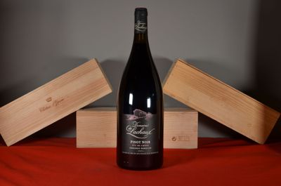 a bottle of wine sitting on a table next to two wooden boxes