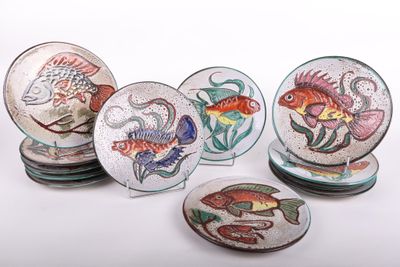 six assiettes ornées de motifs de poissons, posées sur une surface blanche