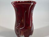 a red vase sitting on a table with a white background