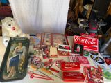 une table sur laquelle sont disposés des objets liés au Coca-Cola et un ours en peluche