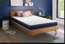 une photo d'une chambre aux murs bleus avec un lit en bois
