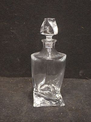 une bouteille en verre transparent posée sur une surface noire