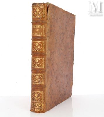 un vieux livre posé sur une table blanche à côté d'un mur blanc