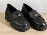 a pair of black loafers on a wooden surface