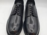 a pair of black leather shoes on a white surface